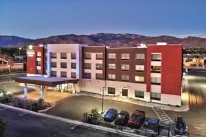 een groot gebouw met auto's geparkeerd voor het bij Holiday Inn Express & Suites - Albuquerque East, an IHG Hotel in Albuquerque