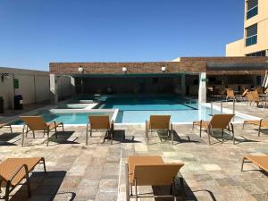a patio with chairs and a swimming pool at Piazza diRoma - Apartamentos JN in Caldas Novas