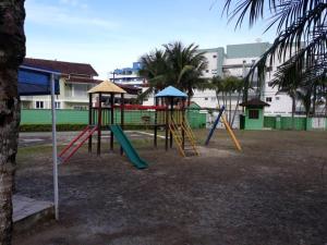 a playground with a slide and a swing set at Associação Sabesp Bertioga - SP in Bertioga