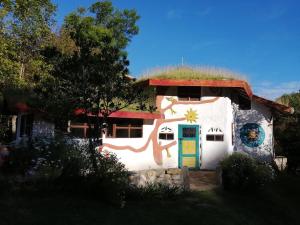 una casa con techo de hierba y una puerta colorida en Jardin Colibri RNT 33633, en Guatavita