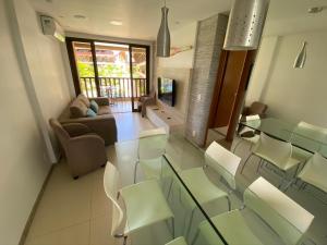 un soggiorno con tavolo e sedie in vetro di OKA Beach Residence a Porto De Galinhas