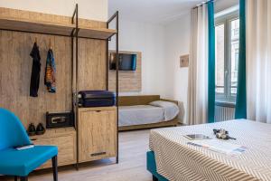 ein kleines Schlafzimmer mit einem Bett und einem Sofa in der Unterkunft Cuneo Hotel in Cuneo