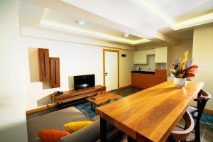 a living room with a wooden table and a kitchen at Continent Luxury Suites Sakarya in Sakarya