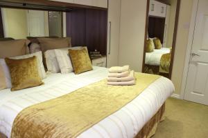 um quarto com uma cama grande e toalhas em Silversprings - City Centre Apartments with Parking em Exeter