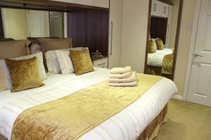a bedroom with a large bed with towels on it at Silversprings - City Centre Apartments with Parking in Exeter