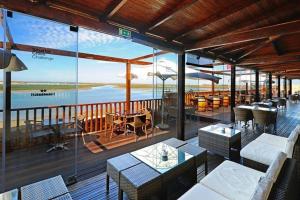 a restaurant with tables and chairs and a view of the ocean at Ria Center Apartment - Right in Faro