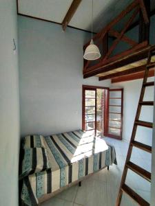 a bedroom with a bed in a room with a ladder at Santa Sereia in Maresias