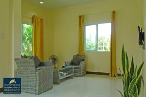 sala de estar con 2 sillas y ventana en MaiKhao Residence, en Mai Khao Beach