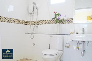 a white bathroom with a toilet and a sink at MaiKhao Residence in Mai Khao Beach