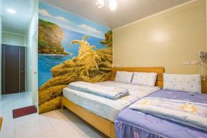 小琉球的住宿－嶼景6.8，一间卧室设有两张床,墙上挂着一幅画