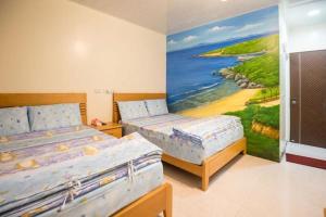 ein Schlafzimmer mit 2 Betten und einem Wandgemälde in der Unterkunft Yu Jing 6.8 in Xiaoliuqiu