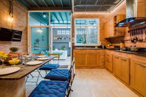 a kitchen with a long table and blue chairs at Luxury City-Loft, just 9 minutes walk to the Beach in Hua Hin