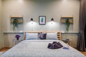 a bedroom with a bed and two plants on the wall at Luxury City-Loft, just 9 minutes walk to the Beach in Hua Hin