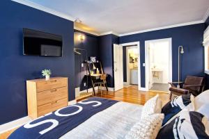 a bedroom with blue walls and a bed and a tv at Nautical Nest Hudson in Hudson