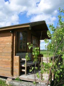 een kleine houten hut met een veranda in een veld bij Chalet in Myza Igaste