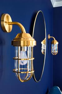 a gold light fixture in a room with a blue wall at Nautical Nest Hudson in Hudson