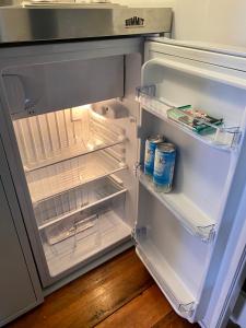 um frigorífico aberto cheio de bebidas e latas de leite em Nautical Nest Hudson em Hudson