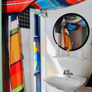 ein Bad mit einem Waschbecken und einem Spiegel in der Unterkunft Hyggeligt ved Ejerslev Havn in Ejerslev