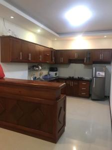 a large kitchen with wooden cabinets and a refrigerator at Căn hộ Sơn Thịnh - Homestay in Vung Tau