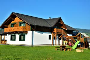 a house with a sandbox and a playground at Apartmán Elenka in Zuberec