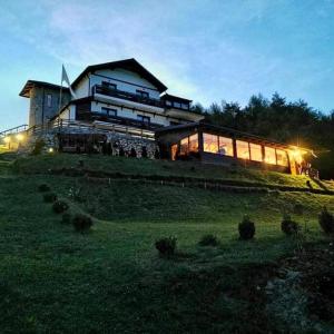 a large house on top of a hill at night at Acasa la Mariuca in Bran