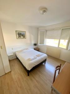 ein Schlafzimmer mit einem Bett und zwei Fenstern in der Unterkunft Hotel du Centre Lucé Chartres in Lucé