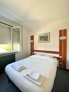 Säng eller sängar i ett rum på Hotel du Centre Lucé Chartres