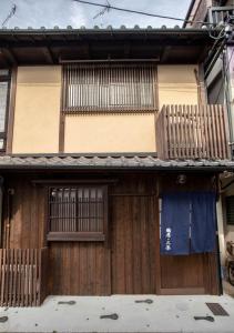 ein Haus mit Holztüren und einem Balkon in der Unterkunft Tsurui Nijo 鶴居二条 in Kyoto