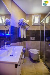 een badkamer met een wastafel, een toilet en een douche bij Kleopatra blue hawai hotel in Alanya