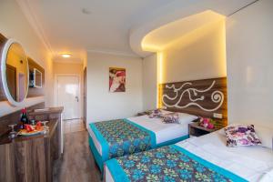 a hotel room with two beds and a table at Kleopatra blue hawai hotel in Alanya