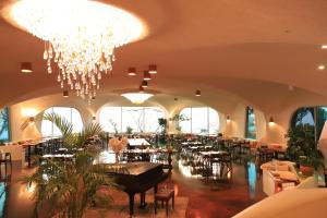 Club ES Jeju Resort في سيوجويبو: مطعم بطاولات وكراسي وثريا