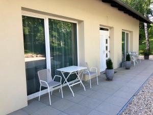 eine Terrasse mit einem Tisch und Stühlen an der Seite eines Hauses in der Unterkunft Gartenhaus5 in Bad Tatzmannsdorf