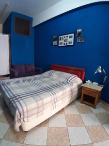 a bedroom with a bed and a blue wall at Studio BLU in Xylophaghou