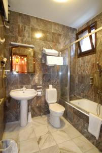 a bathroom with a toilet and a sink and a tub at Kybele Hotel in Istanbul