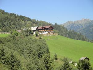 a large house on a hill in a green field at Brandebengut in Bad Hofgastein