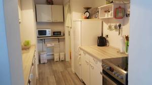 a small kitchen with white cabinets and wooden floors at Ferienwohnung Riemeyer in Lutherstadt Wittenberg