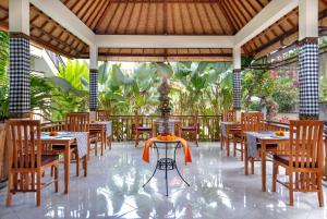 a restaurant with tables and chairs and a fountain at Hidden Padma Retreat in Ubud