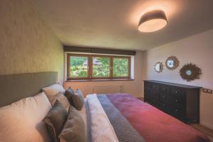een slaapkamer met een bed, een raam en een dressoir bij Apartman Central Ski & Bike in Janske Lazne