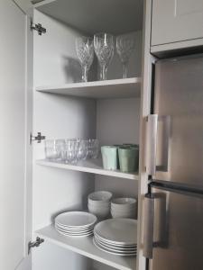 a pantry with plates and wine glasses on shelves at Next door at Broomfield House in Midleton