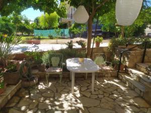 a white table and chairs in a garden at Cozy stone house in Sikéa