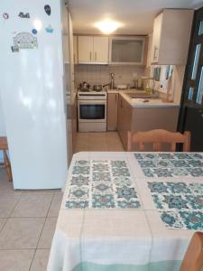 a small kitchen with a table and a refrigerator at Cozy stone house in Sikéa