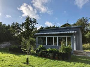 a tiny house in a garden with plants at Mysig nybyggd stuga nära hav och natur in Klövedal