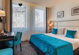 a hotel room with a bed and a desk at Eurostars Danube Budapest in Budapest