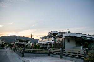 a row of buildings on a street with a fence at Amalia Center in Nea Vrasna