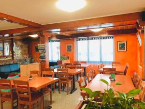 un ristorante con tavoli e sedie in legno e finestre di Bellpark Hostel a Lucerna