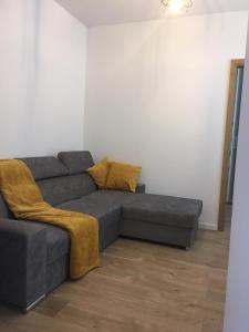 a living room with a gray couch and yellow pillows at Apartament Rynek - Oficyna in Kielce