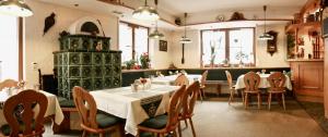 a restaurant with tables and chairs and a green tower at Pension Grünes Herz in Tonndorf