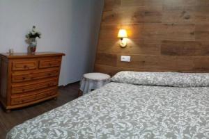 Villalba de Adaja的住宿－Casa Rural Ruplas II，一间卧室配有一张床、梳妆台和一张睡床。