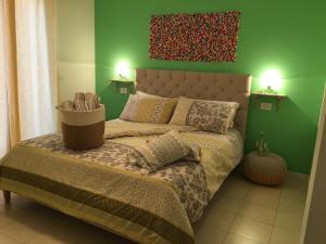 sypialnia z łóżkiem i zieloną ścianą w obiekcie Intra Rooms w mieście Olbia