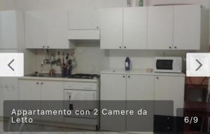 メタポントにあるAppartamento con terrazzoのキッチン(白いキャビネット、電子レンジ付)